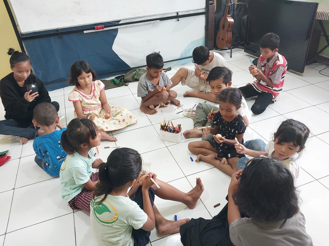 Anak-anak mengerjakan kegiatan kerajinan tangan di lantai ruang kegiatan