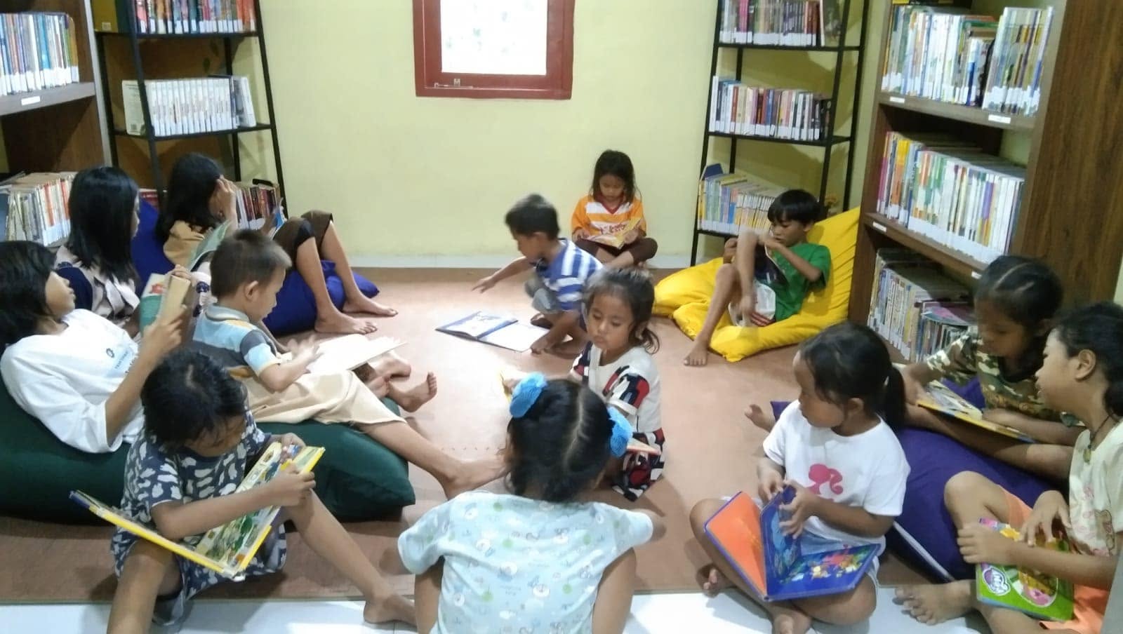 Anak-anak membaca buku bersama di perpustakaan