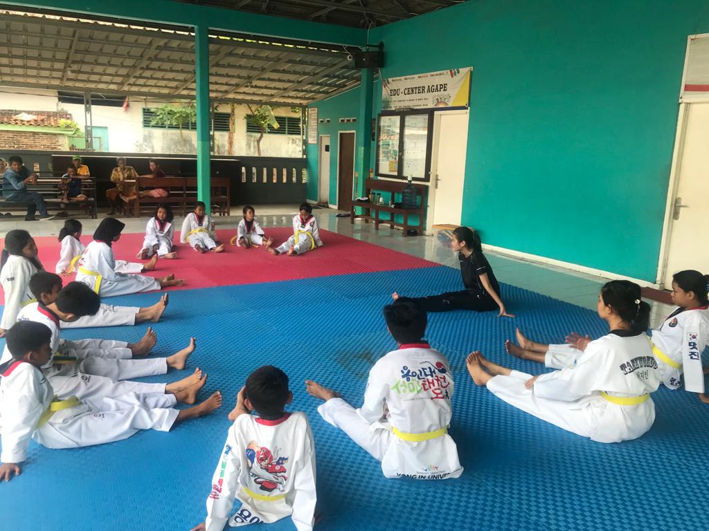 Peserta kelas taekwondo melakukan pemanasan