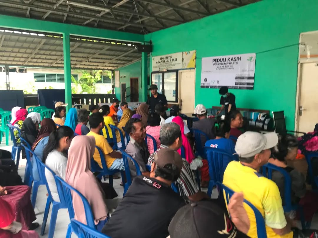 Warga duduk menunggu panggilan pemeriksaan pada layanan pengobatan gratis